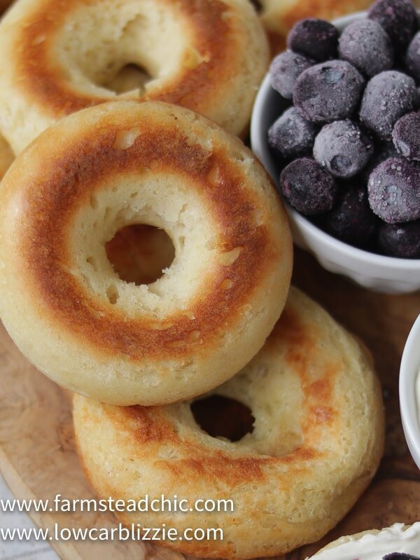 These Low Carb, Keto Bagels are based on the Fathead dough recipe and use mozzarella cheese, cream cheese, almond flour and eggs to make a dough that's surprisingly light and cream-cheese-spreadable. Add some smoked salmon, capers and sliced red onion for a Bagel and Lox. #farmsteadchic #lowcarbbagel #ketobagel #bagelandlox #smokedsalmonbagel #fatheadbagel #lowcarbbreakfast #ketobreakfast
