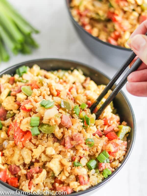 With this Low Carb, Keto Ham Fried Rice (Fried Cauliflower Rice), you can have your takeout and stay low carb too! Freshly riced cauliflower replaces traditional rice, and bell peppers add sweet and savory flavors plus crunch without all the carbs the usual takeout fried rice veggies have. Freshly grated ginger and minced garlic take the whole dish to the next level.  #farmsteadchic #CliftyFarm #countryham #southerncooking #ketofriedrice #lowcarbfriedrice #hamfriedrice