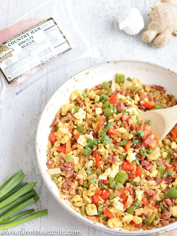 With this Low Carb, Keto Ham Fried Rice (Fried Cauliflower Rice), you can have your takeout and stay low carb too! Freshly riced cauliflower replaces traditional rice, and bell peppers add sweet and savory flavors plus crunch without all the carbs the usual takeout fried rice veggies have. Freshly grated ginger and minced garlic take the whole dish to the next level.  #farmsteadchic #CliftyFarm #countryham #southerncooking #ketofriedrice #lowcarbfriedrice #hamfriedrice