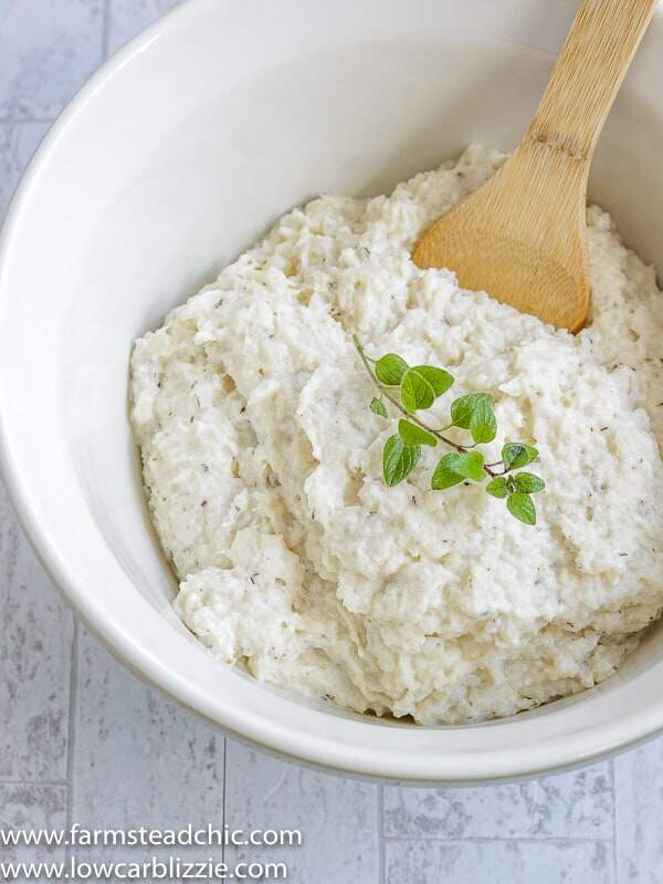 These Low Carb, Keto Mashed Cauliflower Fauxtatoes are super creamy and flavored with plenty of butter, thyme, oregano and garlic. Enjoy them at your next holiday gathering or summer BBQ. They taste like the best-ever garlic herb mashed potatoes with only a fraction of the carbs! #farmsteadchic #ketopotatoes #keto #lowcarb #lowcarbpotatoes #mashedpotatoes #mashedfauxtatoes #fauxtatoes #holidaysidedish #holidaysidedishes #ketosidedish #lowcarbsidedish