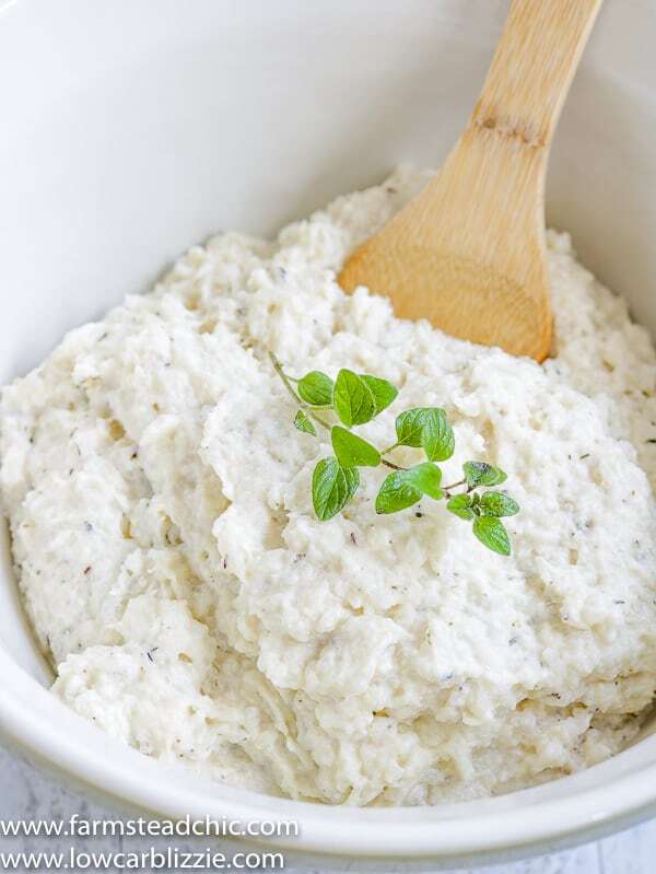 These Low Carb, Keto Mashed Cauliflower Fauxtatoes are super creamy and flavored with plenty of butter, thyme, oregano and garlic. Enjoy them at your next holiday gathering or summer BBQ. They taste like the best-ever garlic herb mashed potatoes with only a fraction of the carbs! #farmsteadchic #ketopotatoes #keto #lowcarb #lowcarbpotatoes #mashedpotatoes #mashedfauxtatoes #fauxtatoes #holidaysidedish #holidaysidedishes #ketosidedish #lowcarbsidedish